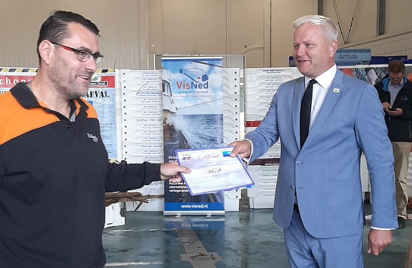 Alderman Kees Visser presenting a Fishing for Litter certificate to a fisherman in Den Helder, the Netherlands.