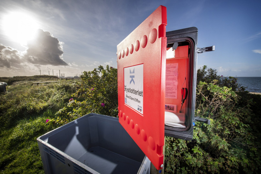 A red 'Coastal Lottery' collection point on a beach in Esbjerg, Denmark.