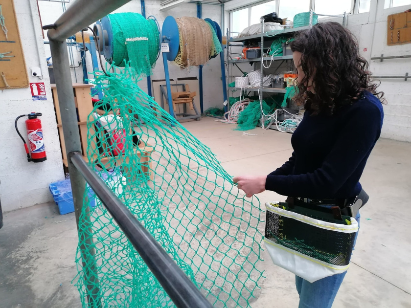 Audugé repairing a net while wearing a 'Sacabout'